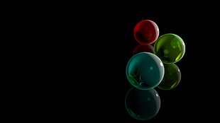 low light photograph of red, green, and blue balls